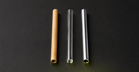 Trois pailles alignées, une paille bambou, une paille verre et une paille inox.