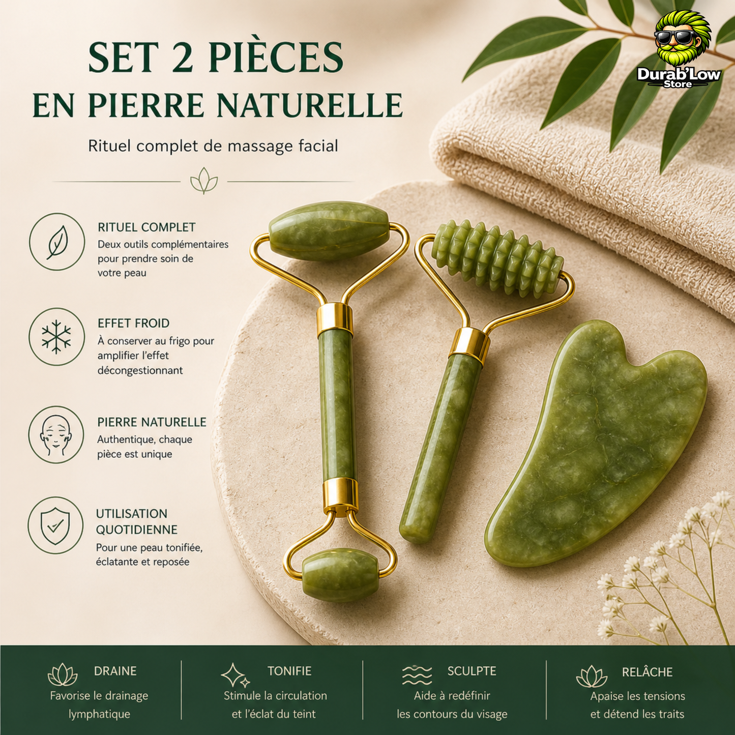 Le gua sha et les 2 rouleaux en pierre de jade sont au centre, sur une pierre blanche. un linge et des feuilles de bambou en fond.