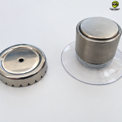 Les deux éléments du porte-savon magnétique. D'un côté la bague dentelée et de l'autre l'aimant et sa ventouse.