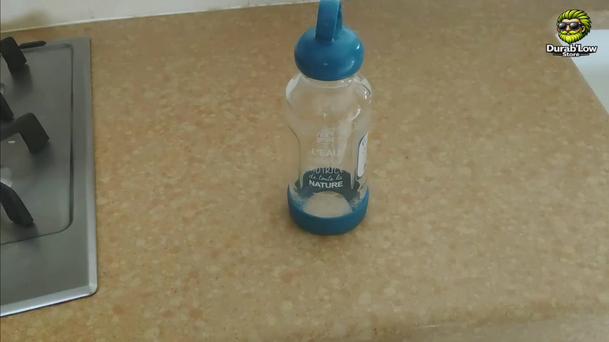 Présentation d’une gourde de 500 ml en verre borosilicate avec bouchon d’origine végétale, anneau de transport et base recyclée amovible. La vidéo montre le démontage de la gourde et précise qu’elle est fabriquée et assemblée en France.